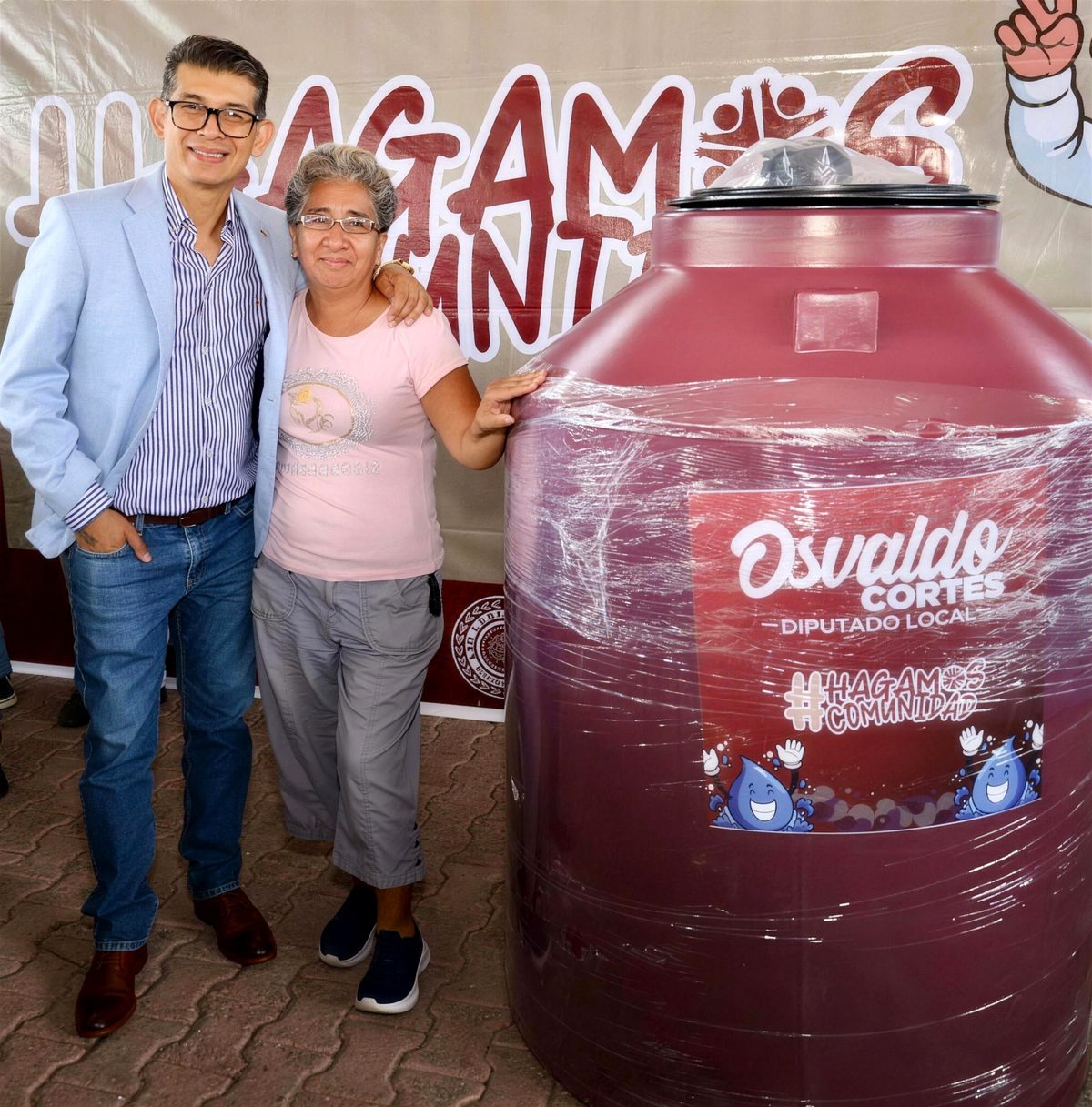 Osvaldo Cortes con una vecina en la entrega de tinacos